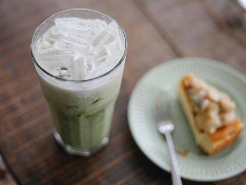 An iced matcha latte on a cafe table, before and after the matcha filter — original
